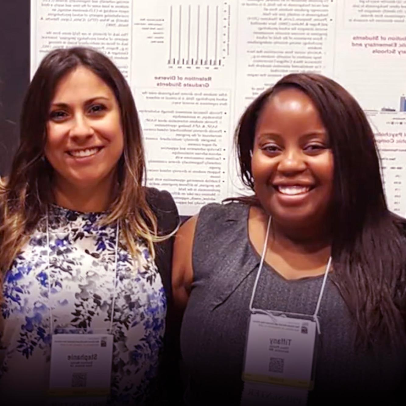 Two women students of Counseling and School Psychology smiling at a conference